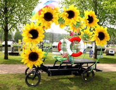 Lastenfahrad fr zwei Fahrer mit bergroen Sonnenblumen und Rettungsringen dekoriert